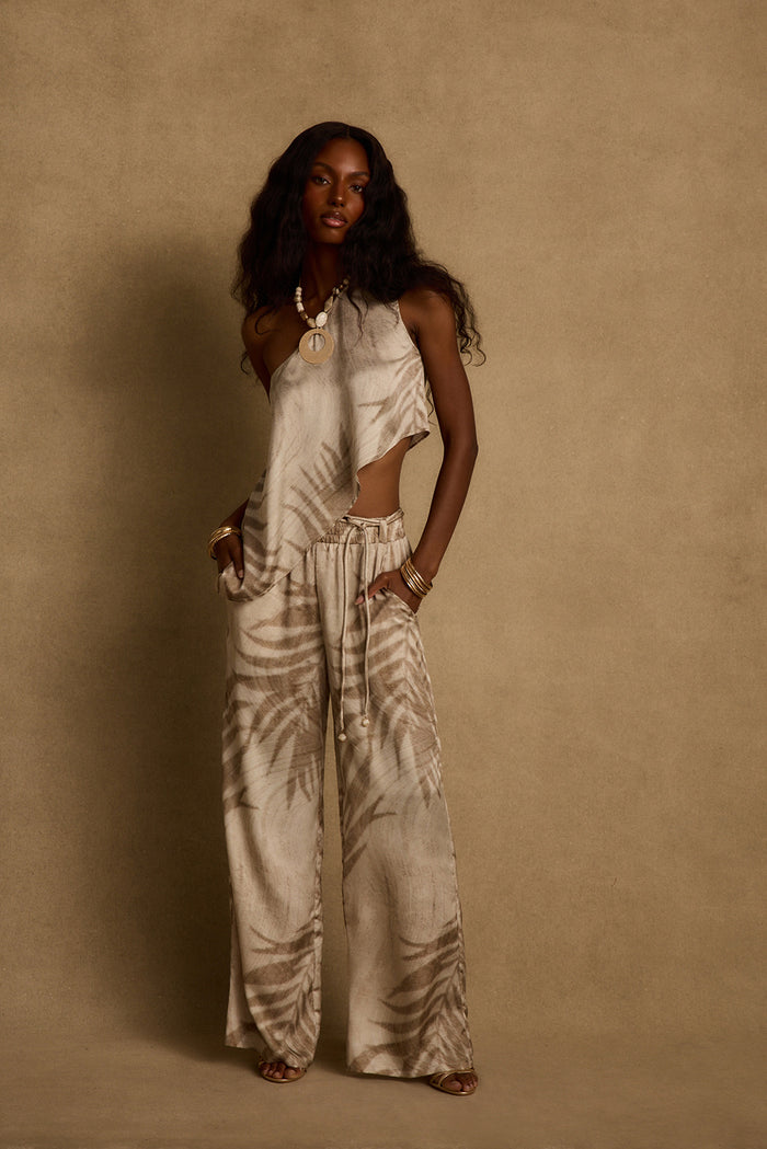 One-shoulder Estelle palm print top styled with matching wide-leg pant and beaded necklace.