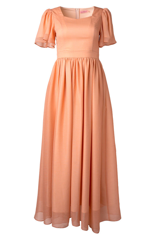 The Abbie Dress in Apricot Crush by Ivy City Co features short puff sleeves, a fitted bodice, gathered waist, and a flowing semi-sheer skirt—an elegant choice for chic bridesmaids.