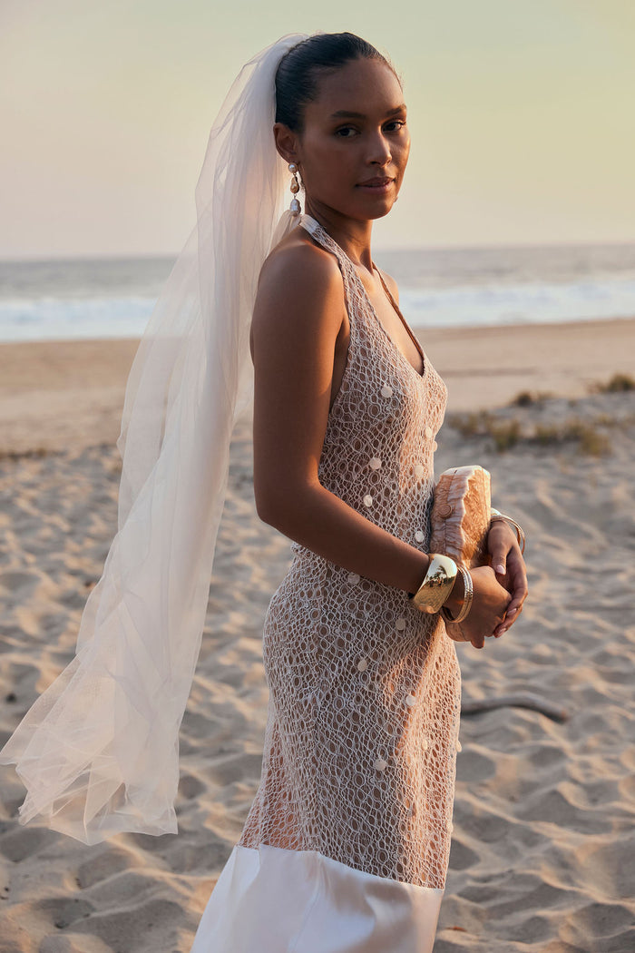 Anastasia pearl embellished lace maxi dress worn with a veil on sand at sunset.