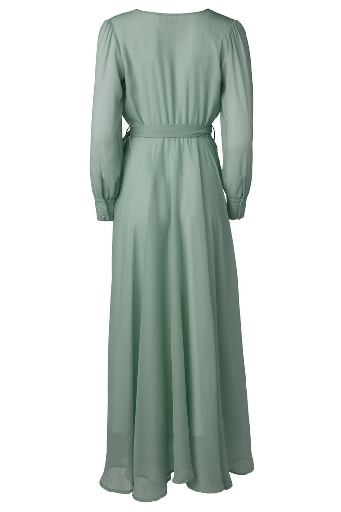 The Andie Dress in Sage by Ivy City Co is a long, light green maxi dress featuring long sleeves, a fitted waist accented with a thin belt, and a flowing skirt shown from the back. Crafted from lightweight, slightly sheer fabric, it’s an elegant choice for bridesmaids.