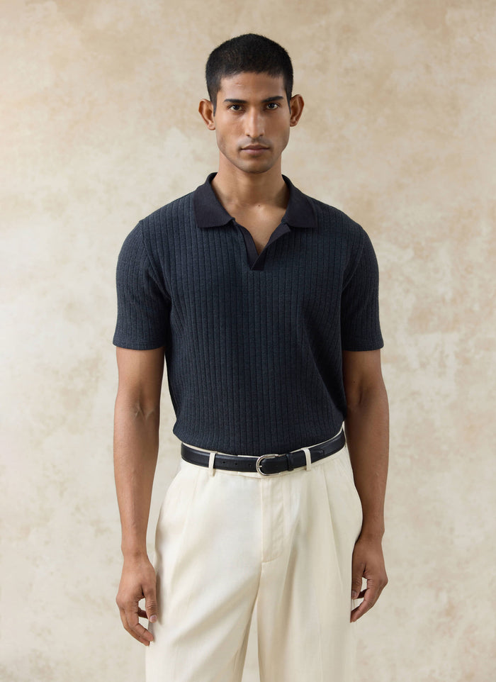 Percival black Anthony Ribbed Polo with a textured knit and open collar, worn by a model with cream trousers.