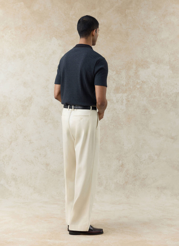 Black Percival Anthony Ribbed Polo in a cotton blend, shown from the back on a model with cream trousers.
