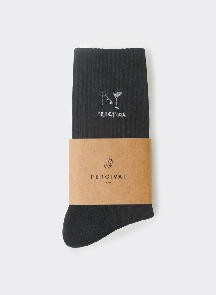 Black ribbed cotton Percival Aperitivo socks with white martini glass embroidery, presented in a brown paper card sleeve.