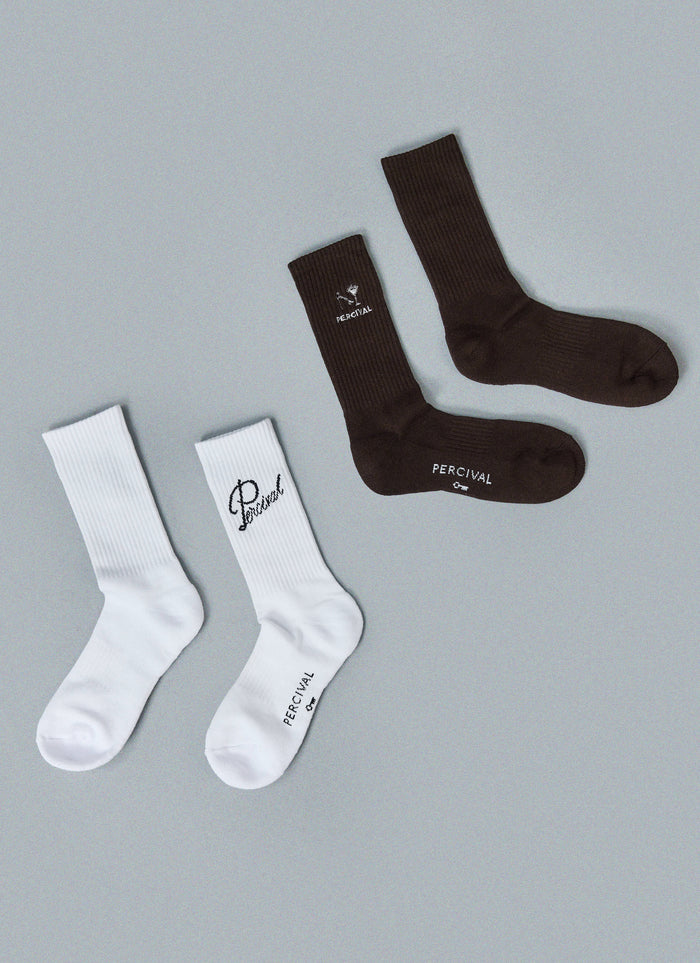 Percival black and white crew socks featuring aperitivo and script embroidery, shown flat against a grey background.