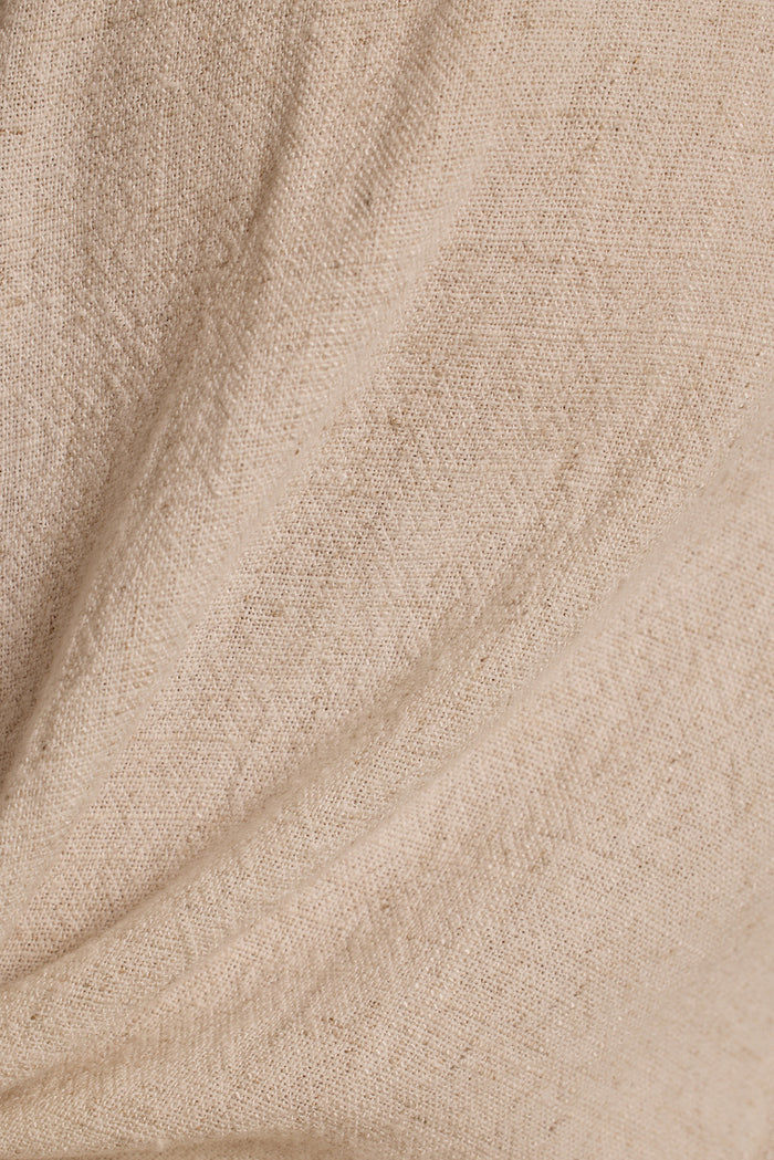 Close-up weave of the Augusta natural linen top, showing soft beige texture and gentle drape.