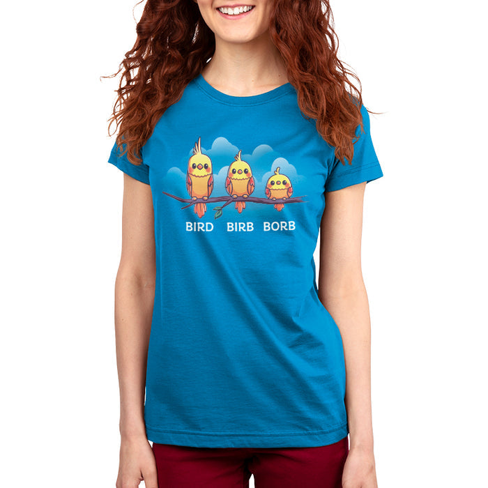 Premium Cotton T-shirt_Teeturtle Bird. Birb. Borb. cobalt blue t-shirt featuring three cartoon birds with varying levels of fluffiness sit on a branch against a blue background with clouds. The birds are labeled "Bird," "Birb," and "Borb" from left to right, adding a playful twist to their names, showcasing the Bird.