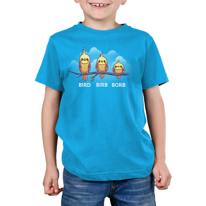 Premium Cotton T-shirt_Teeturtle Bird. Birb. Borb. cobalt blue t-shirt featuring three cartoon birds with varying levels of fluffiness sit on a branch against a blue background with clouds. The birds are labeled "Bird," "Birb," and "Borb" from left to right, adding a playful twist to their names, showcasing the Bird.