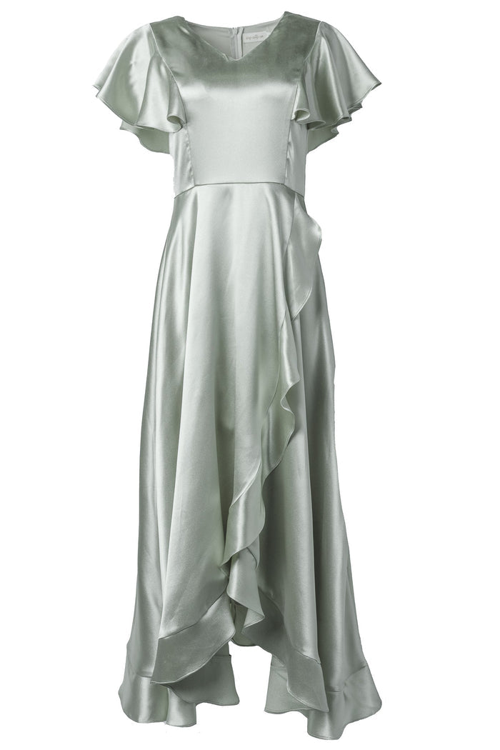 The Callie Dress in Sage Satin by Ivy City Co features light green satin fabric, short sleeves with ruffled detailing, a cascading ruffle down the front, and an asymmetrical hemline—making it the perfect choice for bridesmaids or any bridal party seeking an elegant evening gown.