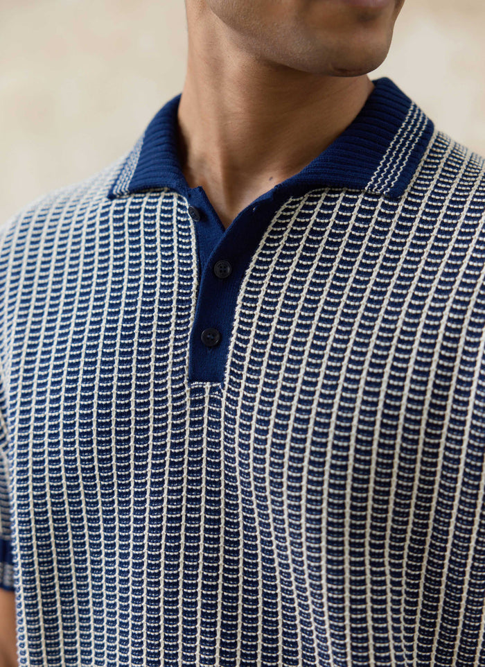Close-up of the navy Claude Knitted Polo by Percival, featuring a two-tone textured cotton knit and ribbed collar.