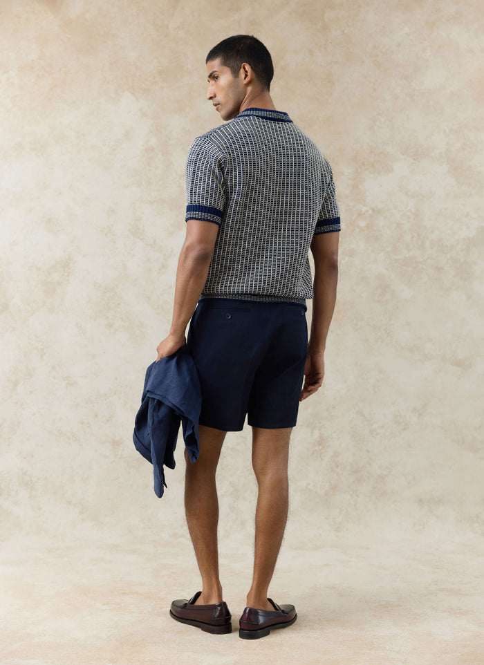 Rear view of the Percival Claude Knitted Polo in navy, featuring a two-tone textured cotton knit and ribbed trims.