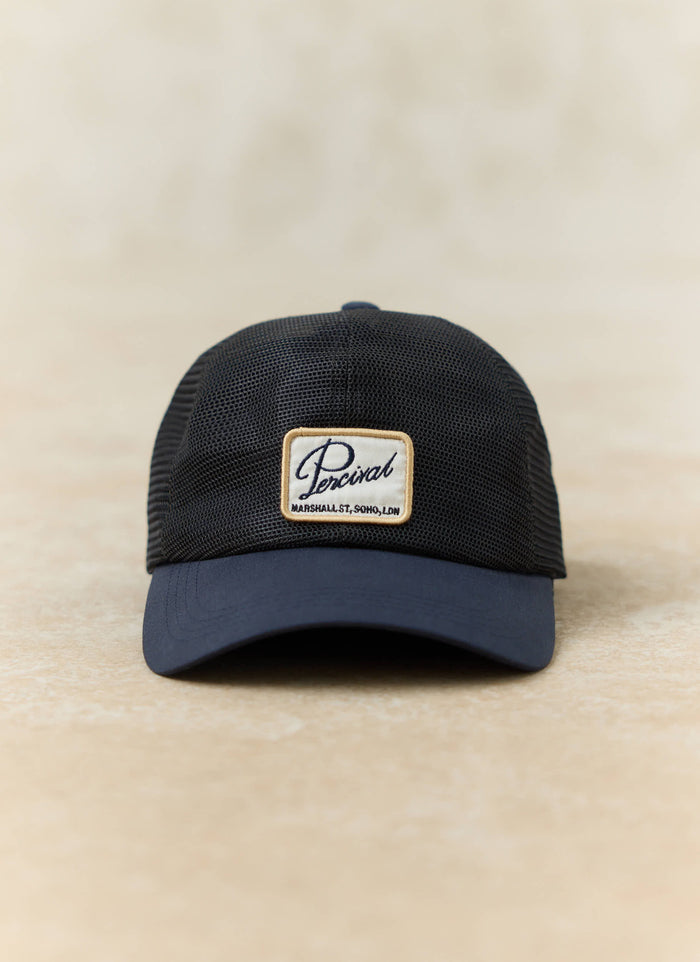 Navy blue Damien mesh trucker cap by Percival, featuring a structured cotton front and a signature Soho logo patch.