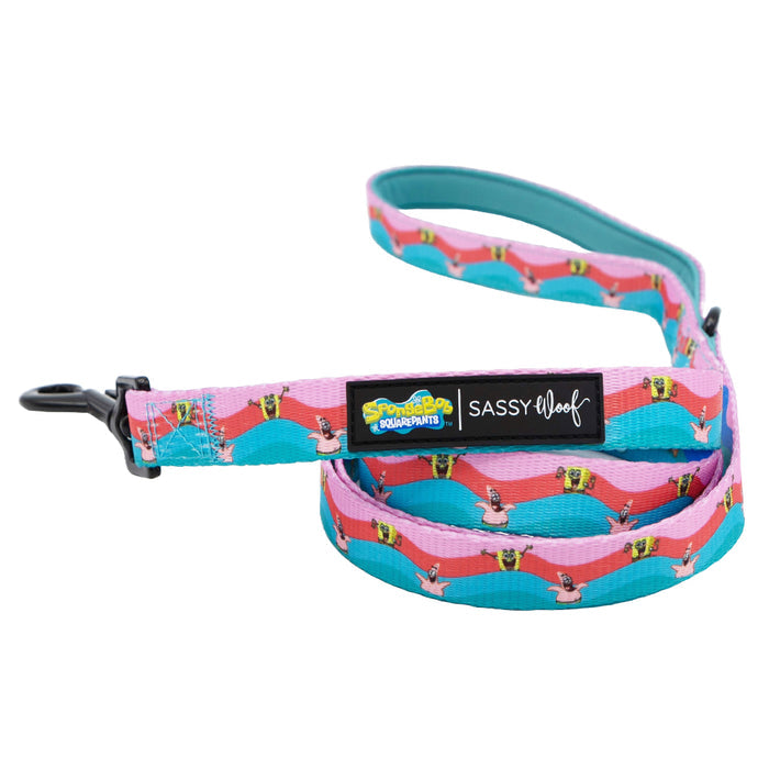 The Sassy Woof Dog Leash - SpongeBob SquarePants™ and Friends features a pink and turquoise Bikini Bottom pattern with SpongeBob images, black metal clasp, and labels for SpongeBob SquarePants and Sassy Woof.