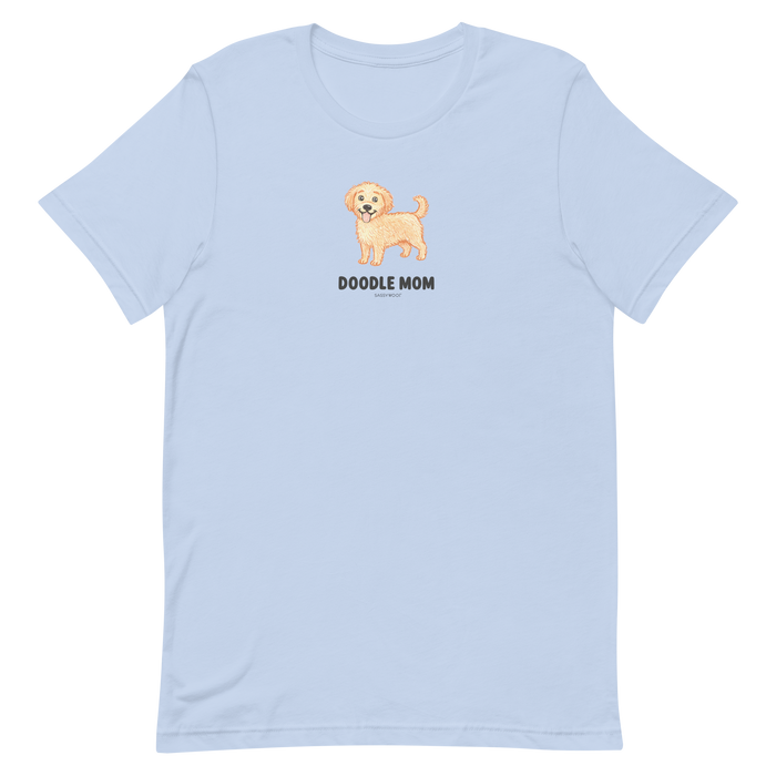 The Doodle Mom Tee by Sassy Woof is a light blue unisex shirt with a smiling tan doodle dog above bold black "Doodle Mom" lettering—perfect for proud doodle owners.