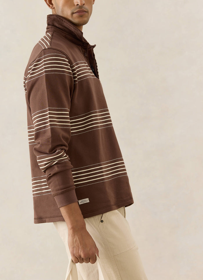 The espresso Percival Editor Striped Rugby Polo with white stab stitching and a cord collar, shown on a model.