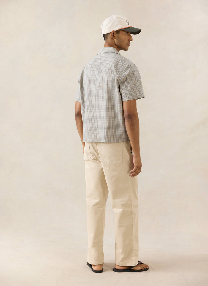 Percival Hinsley cream check boxy short sleeve shirt, styled with a Spencer cap and Lucas carpenter trousers from the back.