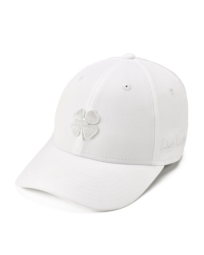 A white baseball cap featuring a glittery silver embroidered four-leaf clover on the front and subtle script embroidery on the side, set against a clean white background.