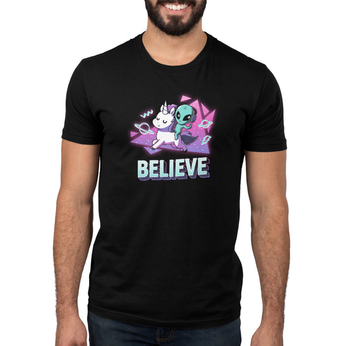 Premium Cotton T-shirt_TeeTurtle black I Believe apparel featuring an alien with headphones on riding a unicorn with a geometric neon 90’s background. Caption says, "BELEIVE".