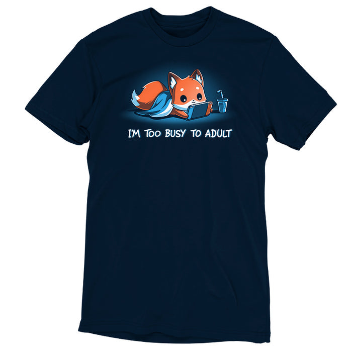 Premium Cotton T-shirt_TeeTurtle I'm Too Busy to Adult navy blue t-shirt featuring a fox lying down with a blue blanket, holding a video game tablet, next to a drink with a straw. Text below reads, "I'M TOO BUSY TO ADULT."