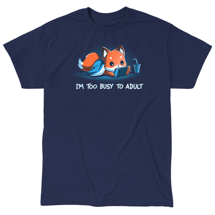 Classic Cotton T-shirt_TeeTurtle I'm Too Busy to Adult navy blue t-shirt featuring a fox lying down with a blue blanket, holding a video game tablet, next to a drink with a straw. Text below reads, "I'M TOO BUSY TO ADULT."