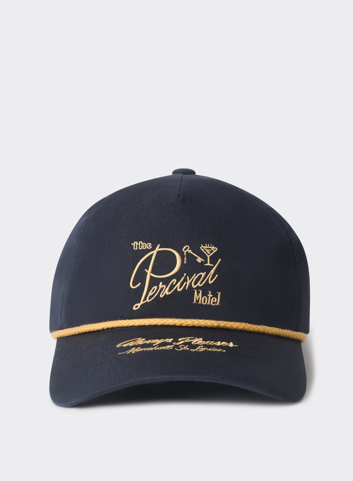 Percival Kingsley navy cotton trucker cap featuring a gold motel logo and braided rope, set against a white background.