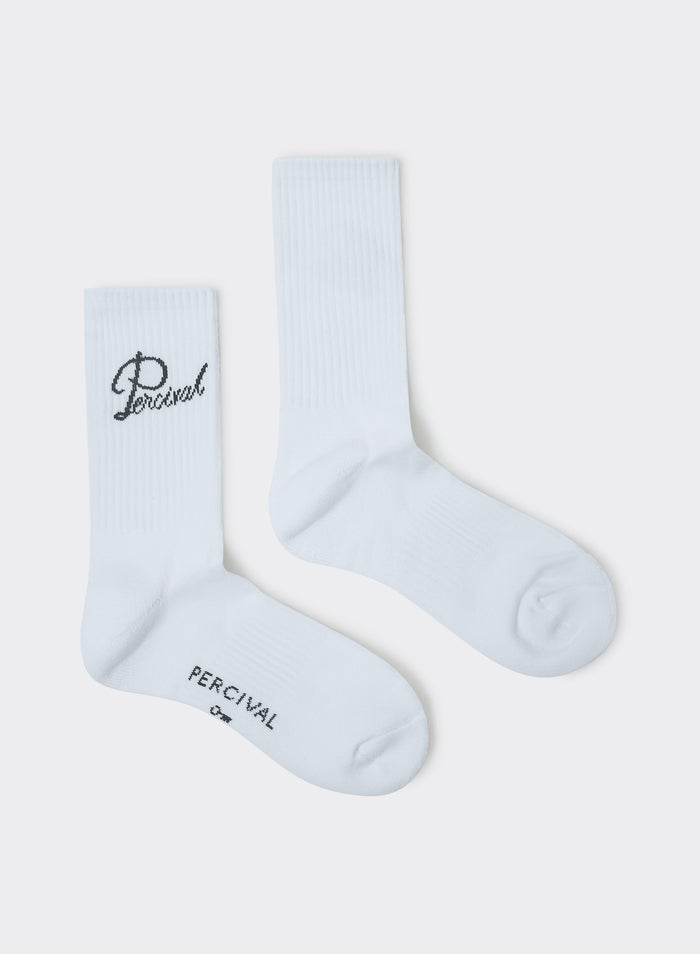 White Percival Kingsley Jacquard Socks in ribbed cotton with script logo embroidery, shown flat against a grey background.