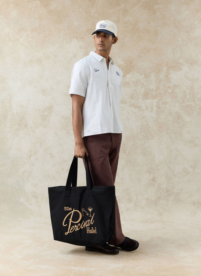 Percival Lucia cream stripe cotton shirt and Donovan trucker cap styled with the large black Kingsley tote bag.