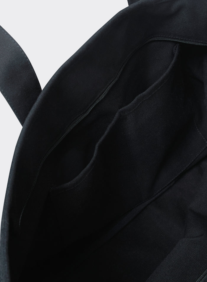 The black cotton interior of the Percival Kingsley Large Tote Bag, highlighting internal pockets and a zip closure.