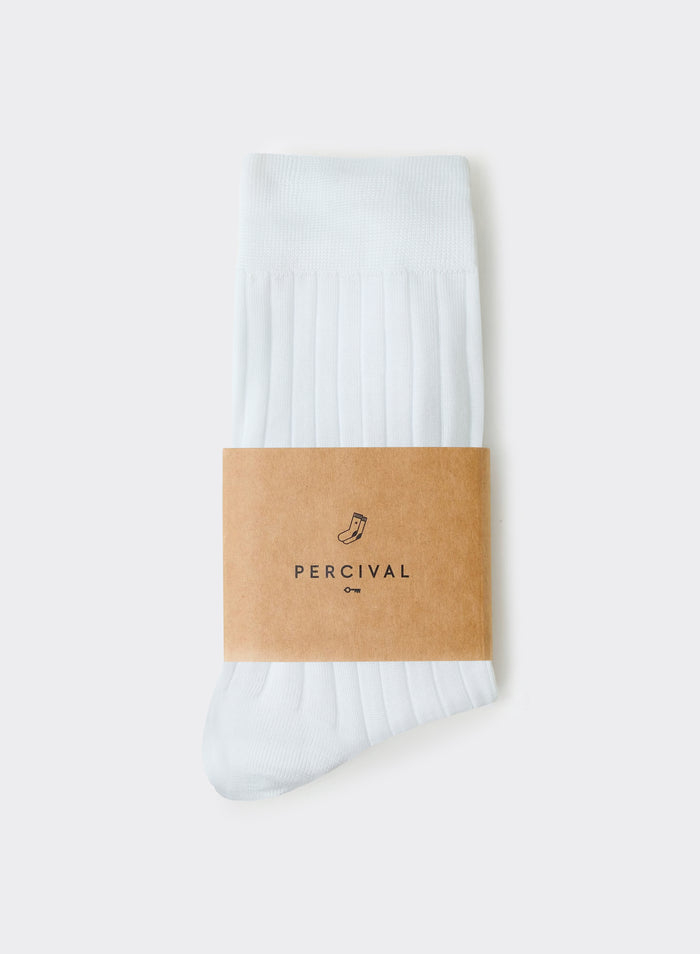 White Percival Loafer Dress Ribbed Socks in 100% cotton, shown folded with a branded brown paper packaging band.