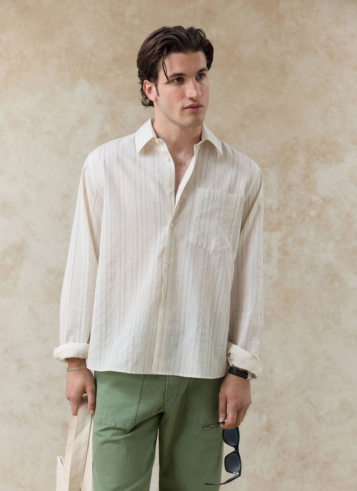The Percival Lorenzo Pearce Shirt in cream stripe, a relaxed lyocell blend shirt styled with green trousers on a model.