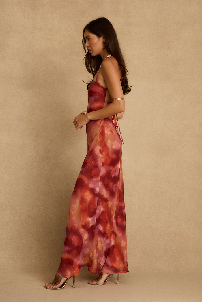 Side profile in the Maris plum floral maxi dress with tie back and gold heels.