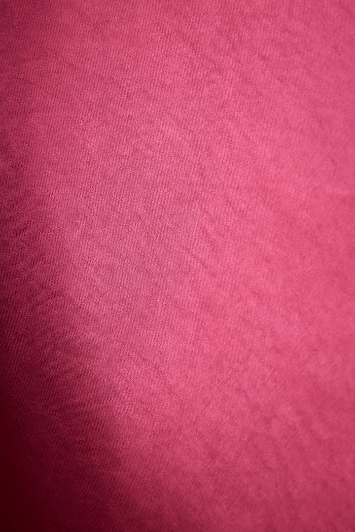 Close-up of fuchsia satin fabric showing the sleek sheen of the Mirabella maxi dress.