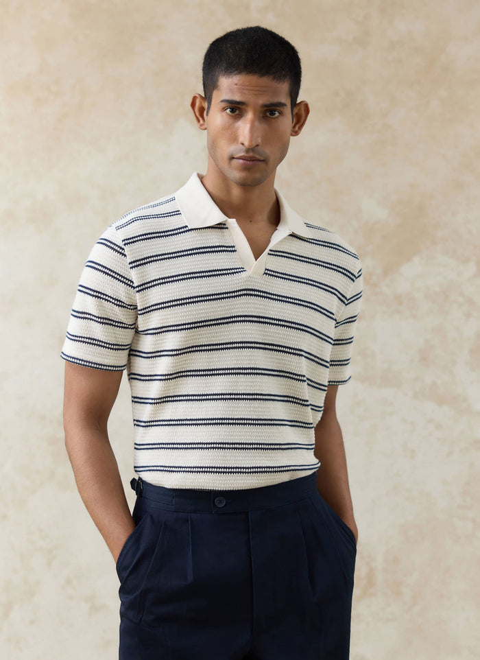 Model wearing the Percival Moore Polo in cream double stripe, a textured cotton knit featuring an open collar.