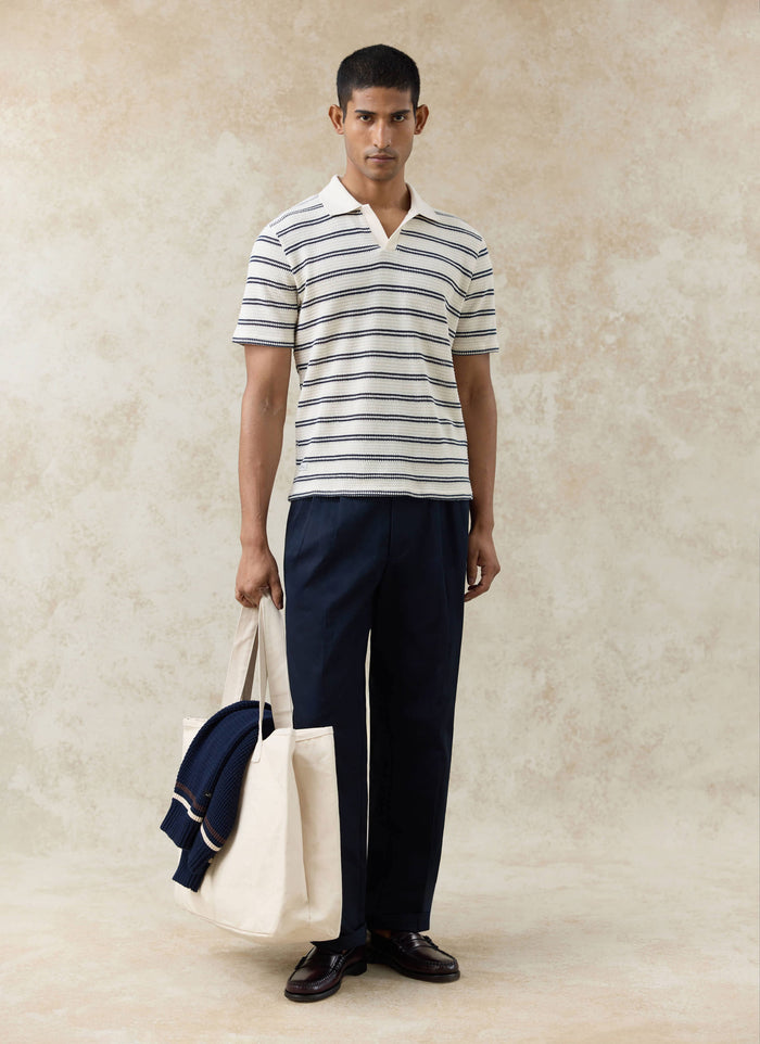 Percival Moore Polo in a cream cotton stripe knit, styled with navy tailored trousers and a cream tote bag.