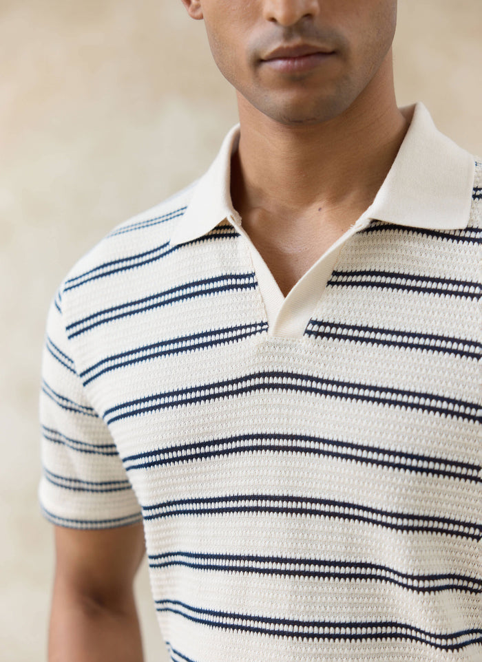Close-up of the Percival Moore Polo in cream textured cotton with black double stripes and an open collar.