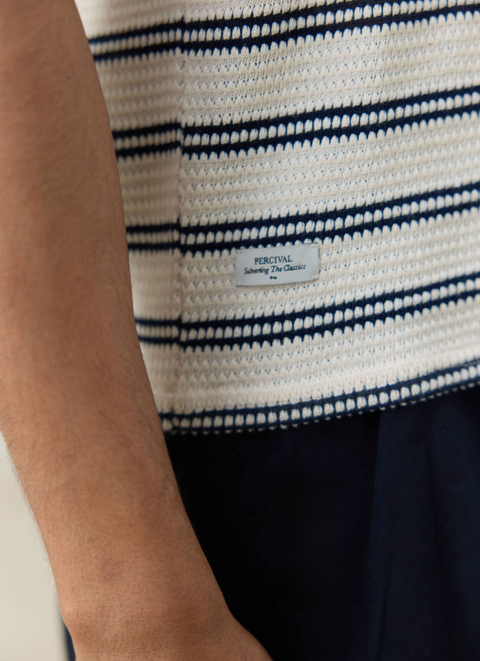 Detailed textured cream cotton and black stripes on the Moore Polo by Percival, featuring the branded woven logo label.