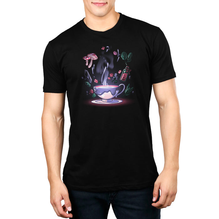 Premium Cotton T-shirt_TeeTurtle Mystic Tea black t-shirt featuring a steaming teacup with a dark liquid inside is surrounded by floating magical cottagecore items, including mushrooms, flowers, leaves, crystals, and a small bottle containing a red potion.