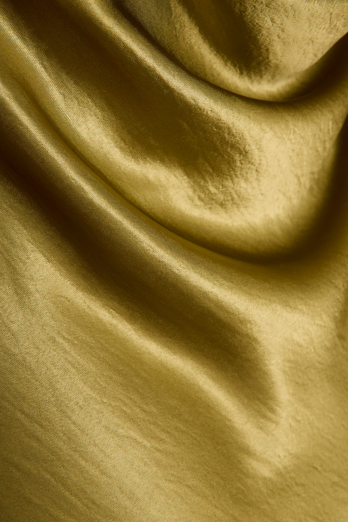 Close-up of chartreuse satin fabric on the Natalia maxi dress, showing soft draped folds.