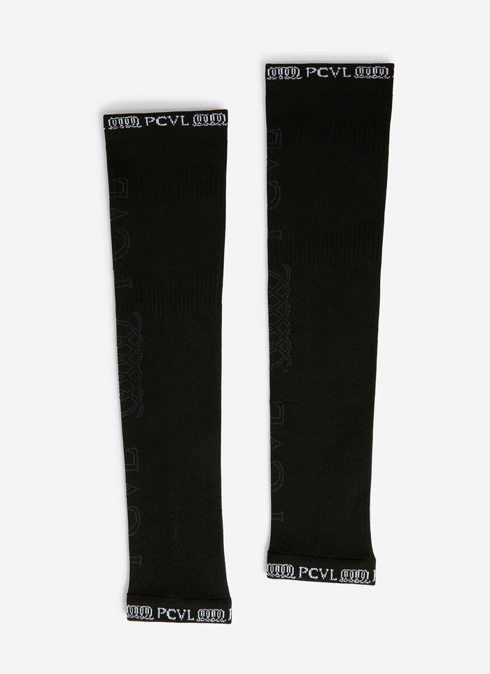 A flat lay of the black PCVL Arm Compression sleeves by Percival, showing the white branded cuffs and subtle jacquard logo.