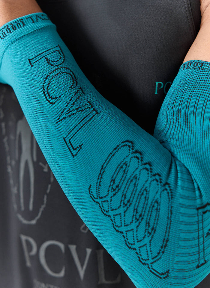A close-up of the Percival PCVL Arm Compression sleeve in blue, showing the detailed black jacquard branding and logo.