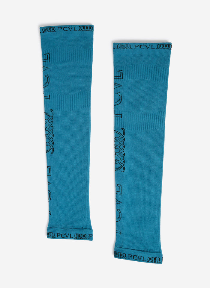 A flat lay of the blue PCVL Arm Compression sleeves by Percival, showing the black jacquard branding details.