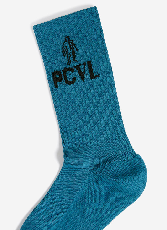 A close-up of the blue PCVL Sport Socks from Percival, showing the black jacquard skeleton PCVL graphic on the ribbed cuff.