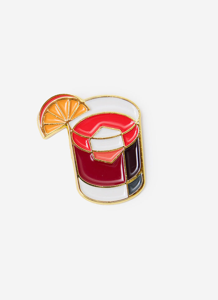 The Percival Negroni pin badge, a multi-coloured metal accessory designed in the shape of the classic cocktail.