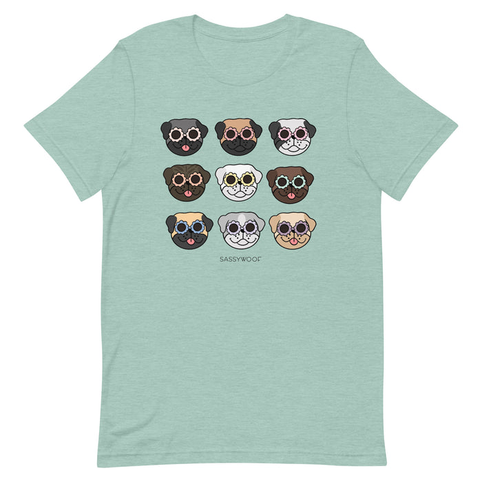 The Pug Tee by Sassy Woof is a mint green unisex shirt with nine colorful cartoon pug faces and "SASSYWOOF" text—an ideal addition to any dog lover’s collection.