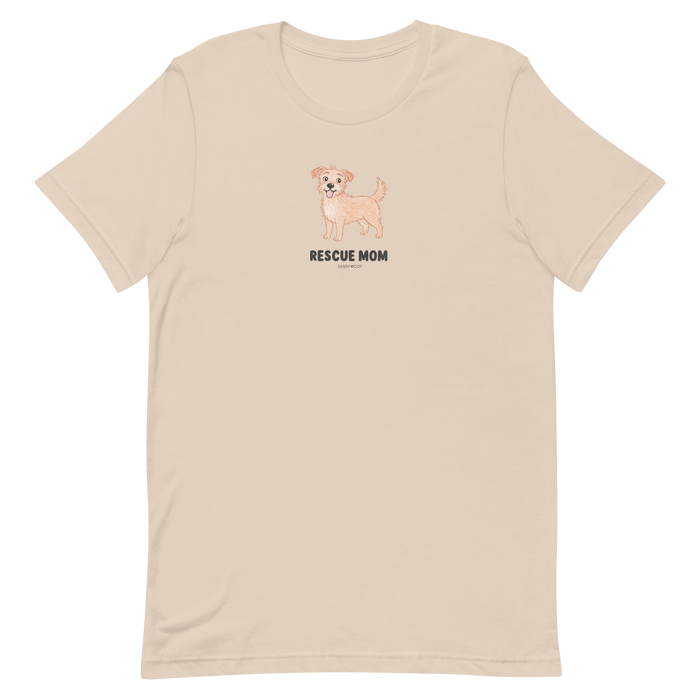 The Sassy Woof Rescue Mom Tee is a unisex beige cotton t-shirt with a small light brown dog illustration above “RESCUE MOM” on the chest, perfect for proud rescue pet parents.