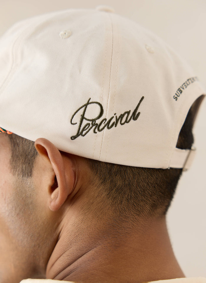 Cream brushed cotton Percival Spencer trucker cap with green script embroidery and a pop of colour rope detail.