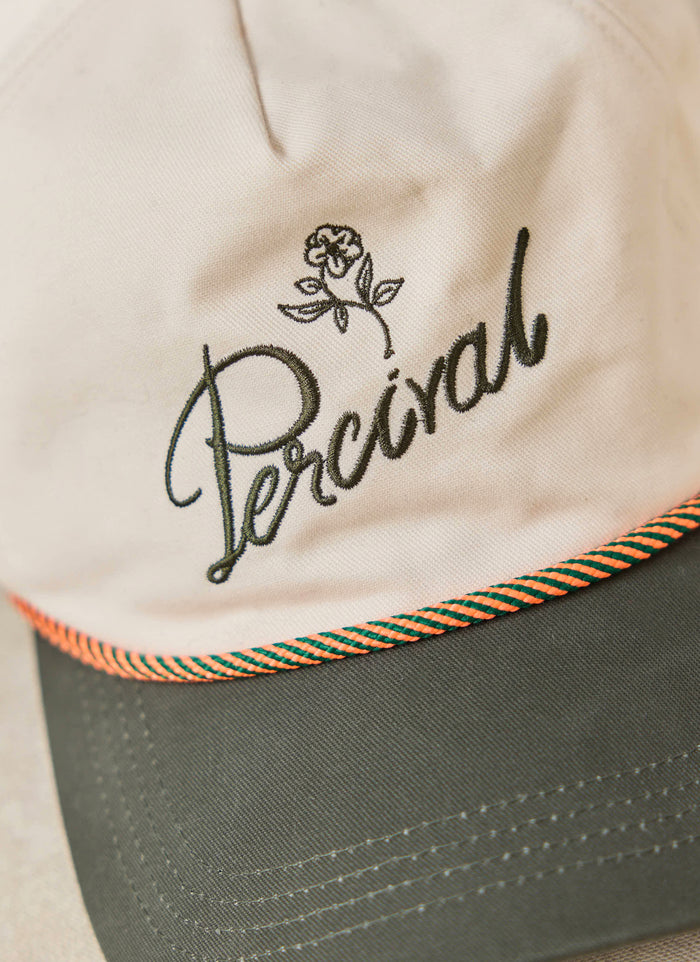 The cream Percival Spencer Trucker Cap in brushed cotton, with green script embroidery and a pop of colour rope detailing.