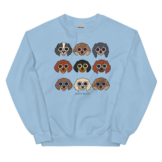 The Sassy Woof Sweatshirt - Doxies is a light blue unisex crewneck with nine cartoon dachshunds in sunglasses and “SASSY WOOF” below—fun, playful apparel for dog lovers.