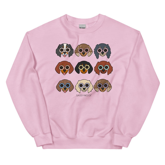 The Sassy Woof Sweatshirt - Doxies is a light pink unisex crewneck with nine cartoon dachshunds in sunglasses, arranged in a 3x3 grid and "SASSYWOOF" below—fun dog lover apparel.