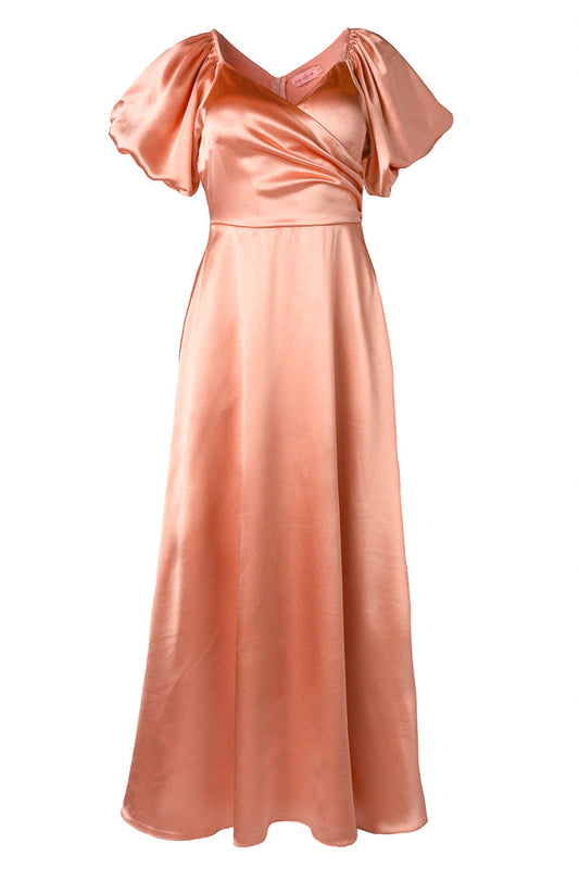 The Tessie Dress in Apricot Crush by Ivy City Co features peach-colored satin, short puff sleeves, a V-neckline, fitted waist, and a long flowing skirt. This nursing-friendly dress is perfect for formal occasions.