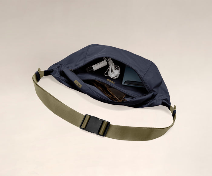 Main compartment packed with a wallet, headphones, and sunglasses